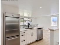 Bright kitchen features stainless steel appliances, white cabinets, and sleek countertops at 235 S Stuart St, Denver, CO 80219