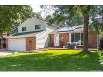 Charming two-story home with a brick facade, solar panels, and a well-maintained lawn at 2254 S Eagle St, Aurora, CO 80014