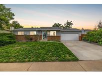 Charming single-story home with a well-manicured lawn, brick accents, and an attached two-car garage at 11886 Birch Dr, Thornton, CO 80233