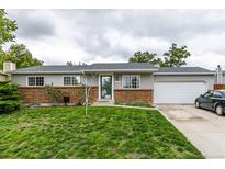 Charming single-story home with brick accents, gray siding, and a well-manicured lawn at 11886 Birch Dr, Thornton, CO 80233