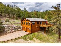 Attractive home exterior with a deck, two-car garage, and wooded landscape at 310 Wendelyn Way, Boulder, CO 80302