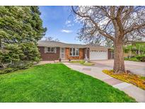 Charming brick home features a lush front lawn, mature trees, and a welcoming two-car garage at 11157 W Marlowe Ave, Jefferson, CO 80127