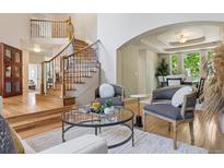 Inviting living room with a staircase, hardwood floors and comfortable seating area bathed in natural light at 6393 S Jamaica Ct, Englewood, CO 80111