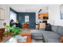 Modern living room featuring a gray sectional sofa, open layout, and a cozy atmosphere at 909 N Logan St # 8F, Denver, CO 80203