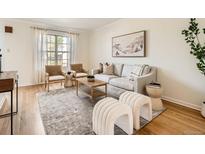 Bright living room with a cozy sofa, stylish chairs, textured rug, and ample natural light at 2301 E Fremont Ave # W03, Centennial, CO 80122