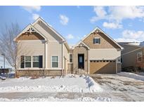 Two-story house with beige siding, brown accents, and a two-car garage at 7394 S Scottsburg Way, Aurora, CO 80016