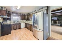 Traditional kitchen featuring wood cabinets, light countertops, and a stainless steel refrigerator at 661 S Paris St, Aurora, CO 80012