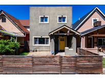 Charming two-story home featuring a bright yellow door and neat front yard landscaping at 433 Fox St, Denver, CO 80204