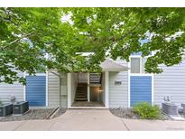 Inviting entrance with stairs and blue-grey walls and a small garden at 1301 S Cathay Ct # 104, Aurora, CO 80017
