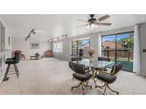 Bright living area features a dining table, bar, and sliding glass doors to the backyard at 7644 Wyandot St, Denver, CO 80221
