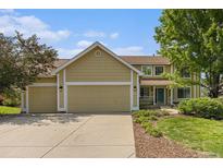 Charming two-story home with a three-car garage, manicured landscaping, and a welcoming entrance at 9346 Lark Sparrow Dr, Highlands Ranch, CO 80126