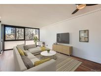 Bright living room featuring hardwood floors, large windows, and modern decor, with a cozy sectional sofa at 1050 N Corona St # 308, Denver, CO 80218