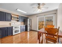 Modern kitchen with stainless steel appliances, blue cabinets and a dining table next to sliding doors at 8915 Field St # 116, Broomfield, CO 80021
