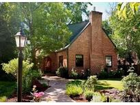 Charming brick home with a manicured lawn and lush landscaping at 357 Birch St, Denver, CO 80220