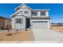 Charming two-story home featuring a gray exterior, well-manicured landscaping, and an attached two-car garage at 9151 Telluride Ct, Commerce City, CO 80022