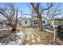 Charming home featuring a stone walkway leading to the front door, mature trees, and a well-maintained yard at 2024 Ford St, Golden, CO 80401