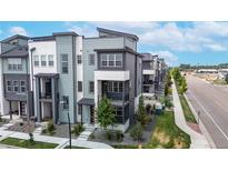 Modern townhome showcases multi-tone color scheme, landscaping, and inviting red door at 6799 Navajo St, Denver, CO 80221
