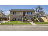 Charming two-story home with manicured lawn and brick accents at 6488 E 63Rd Pl, Commerce City, CO 80022
