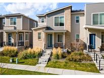 Charming townhouse with a modern design, showcasing a brick facade and well-maintained front yard landscaping at 12273 Karls Ln, Northglenn, CO 80241