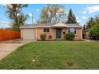 Charming brick home with a well-manicured lawn and mature trees at 5930 W 34Th Ave, Wheat Ridge, CO 80212