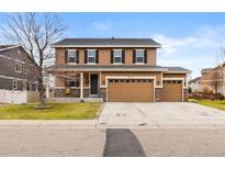 Charming two-story home featuring a three-car garage and a covered front porch at 4814 Monarch Dr, Firestone, CO 80504