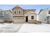 Two-story house with a neutral color palette and a snow covered front yard at 819 Goodrich Peak St, Erie, CO 80516