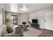 Bright living room featuring a cozy fireplace, modern furnishings, and access to a private balcony at 8335 Fairmount Dr # 9-206, Denver, CO 80247