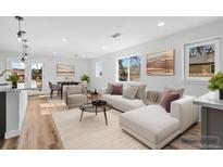 Bright living room with a white sectional, modern decor, and plenty of natural light at 127 Emerald St, Broomfield, CO 80020