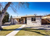 Charming brick home with a cozy front porch and well-manicured lawn, perfect for curb appeal at 3455 Teller St, Wheat Ridge, CO 80033
