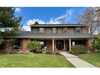 Charming two-story home with brick accents, shutters, manicured lawn, and covered porch at 8503 E Jamison Ave, Centennial, CO 80112
