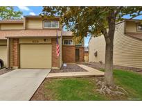 Charming townhome features a brick facade, attached garage, and well-maintained landscaping at 15323 E Louisiana Ave, Aurora, CO 80017