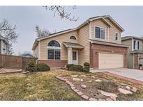 Charming home with a two-car garage, manicured lawn, and brick accents at 5300 Morning Glory Pl, Highlands Ranch, CO 80130