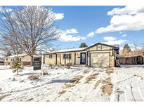 Brick ranch home with attached garage and snow-covered front yard at 8509 Ames St, Arvada, CO 80003