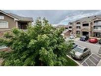 Exterior view of the apartment complex showcasing the building's architecture and surrounding parking area at 7440 S Blackhawk St # 208, Englewood, CO 80112
