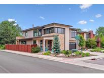 Contemporary home featuring stone accents, manicured landscaping, and a bright red front door at 4274 E Dickenson Pl, Denver, CO 80222