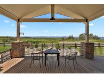Covered deck area with seating offering views of the surrounding landscaped yard at 1975 Wild Star Way, Castle Rock, CO 80104