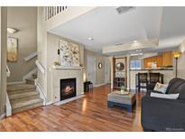 Inviting living room with a cozy fireplace and an open layout to the kitchen area at 1320 S Monaco St Pkwy # 3, Denver, CO 80224