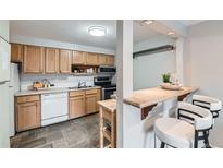 Charming kitchen with stainless steel appliances, light wood cabinets, and a breakfast bar with seating at 1008 N Corona St # 205, Denver, CO 80218