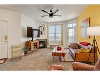 Bright living room featuring a cozy fireplace and a large window for natural light at 5723 N Gibralter Way # 205, Aurora, CO 80019