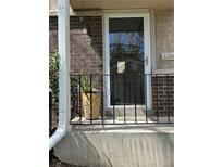 Inviting front porch with a glass door, charming black railings, and a lovely planter with greenery adding to the curb appeal at 6917 E Girard Ave, Denver, CO 80224