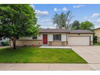 Charming ranch-style home featuring a cozy front porch, well-maintained lawn, and attached garage at 6508 S Garland Way, Littleton, CO 80123