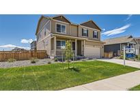 Two-story home with a well-manicured lawn, a covered porch, and an attached two-car garage at 1005 Ryland Rd, Brighton, CO 80603