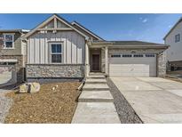 Charming home featuring stone accents, vertical siding, well-maintained landscaping and an attached two-car garage at 22015 E 39Th Ave, Aurora, CO 80019