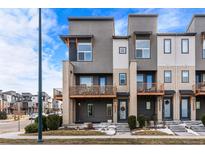 Modern townhome with a contemporary facade, private balconies, and a welcoming entrance at 10031 Town Ridge Ln, Lone Tree, CO 80124