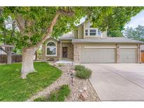 Charming two-story home with a well-maintained lawn, mature trees, and a two-car garage at 4858 S Queen St, Littleton, CO 80127