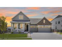 Beautiful two-story home featuring a covered porch, two-car garage, and well-maintained lawn at 5128 Preserve Pl, Firestone, CO 80504