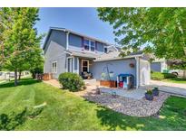 Charming two-story home with blue siding, landscaped front yard, and inviting curb appeal at 165 Montgomery Dr, Erie, CO 80516