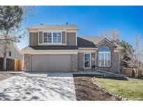 Charming two-story home featuring a brick facade, manicured lawn, and attached two-car garage at 5821 S Quatar Cir, Centennial, CO 80015