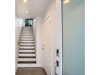 Bright entryway featuring stairs with metal railing, white door, frosted glass door, and tile flooring at 1919 W 46Th Ave # 3, Denver, CO 80211