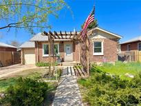 Charming brick home featuring a pergola and a well-manicured front yard at 1965 Havana St, Aurora, CO 80010